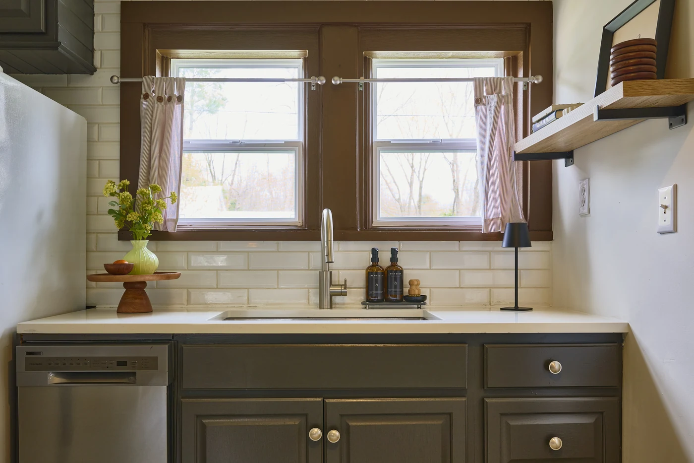Kitchen sink detail at The Lakeside at Sylvan — dark cabinets, subway tile, and curated amenities